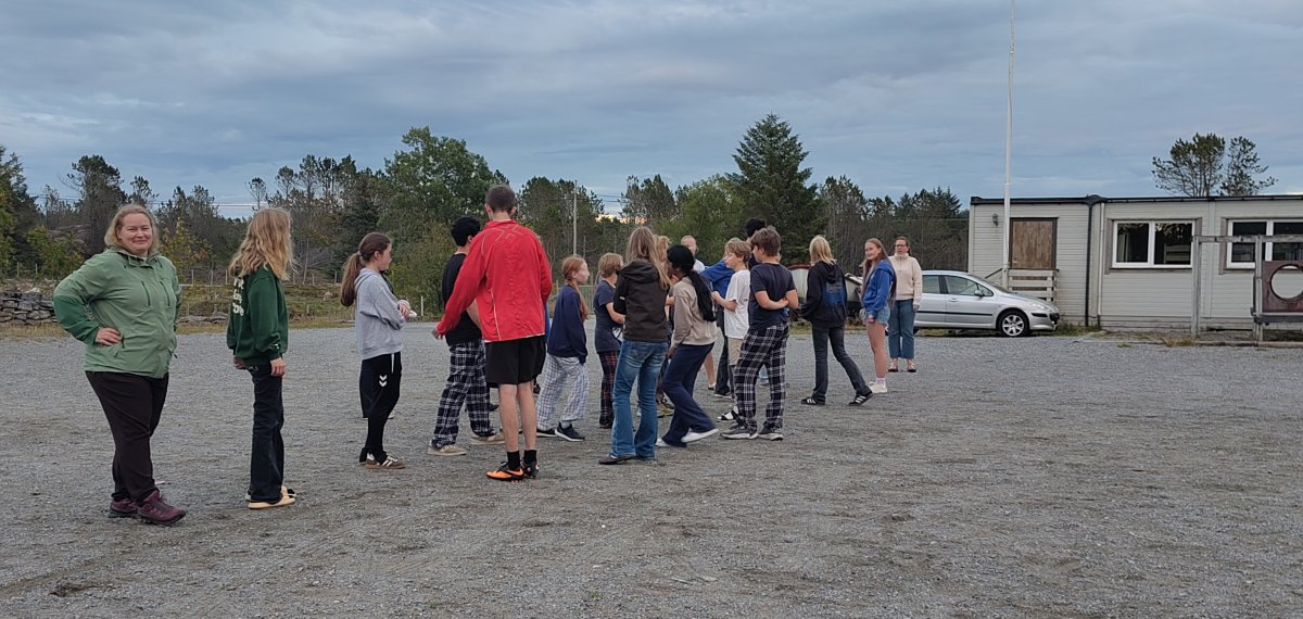 Gjengen ute med fellesaktivitet på kveldstid. 13 ungdommar og tre vaksne er synleg på biletet.